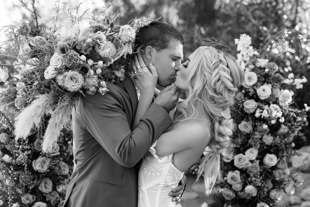 bride and groom kissing while being surrounded by florals, texas elopement photography