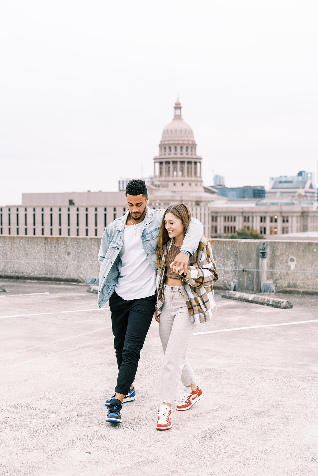 man puts his arm around woman while walking in texas couples photoshoot location