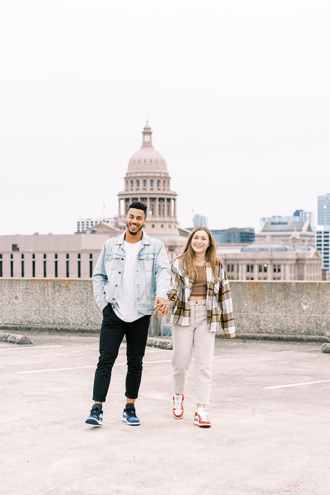 A happy couple walking together while holding hands during couples photoshoot in Texas