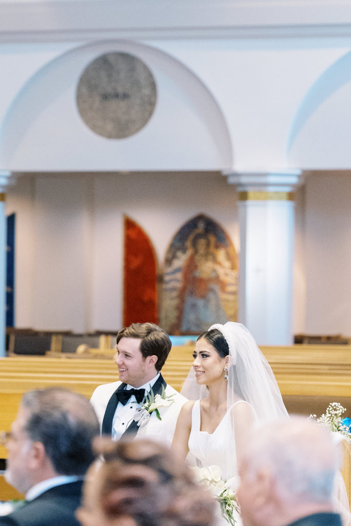 Bride and Groom sitting down during ceremony at church. Texas Wedding Photographer