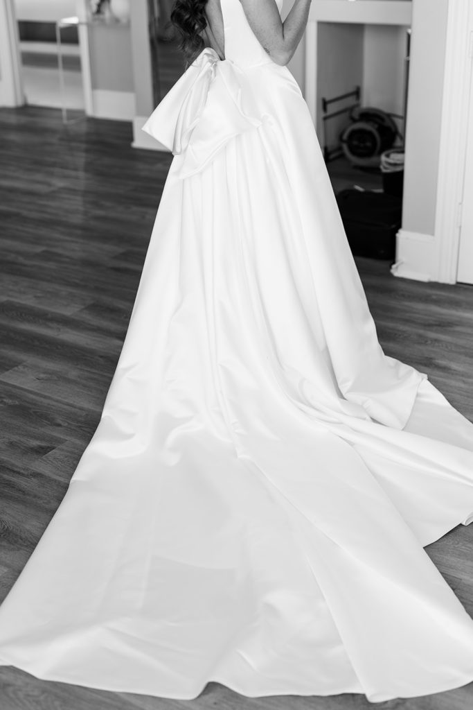 Black and white photo of bride wearing wedding gown. Princess like wedding gown with bow in back. Texas Wedding Photographer