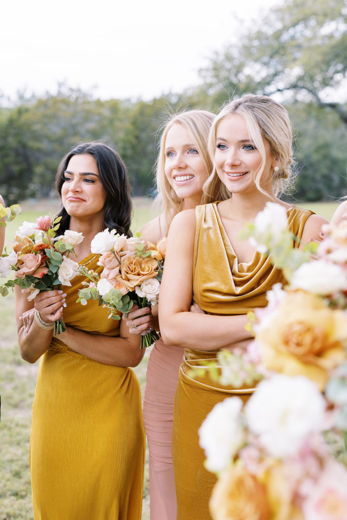 bridesmaids smiling and holding flower bouquets at wedding venue in Texas