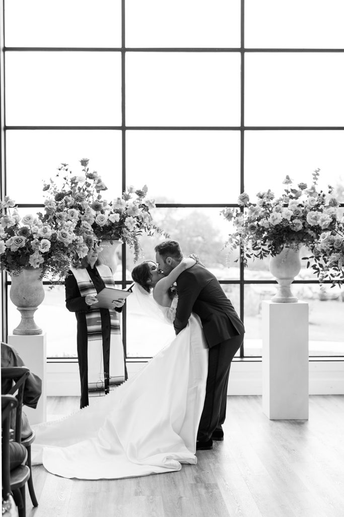 bride and groom kissing at wedding alter at texas wedding venue