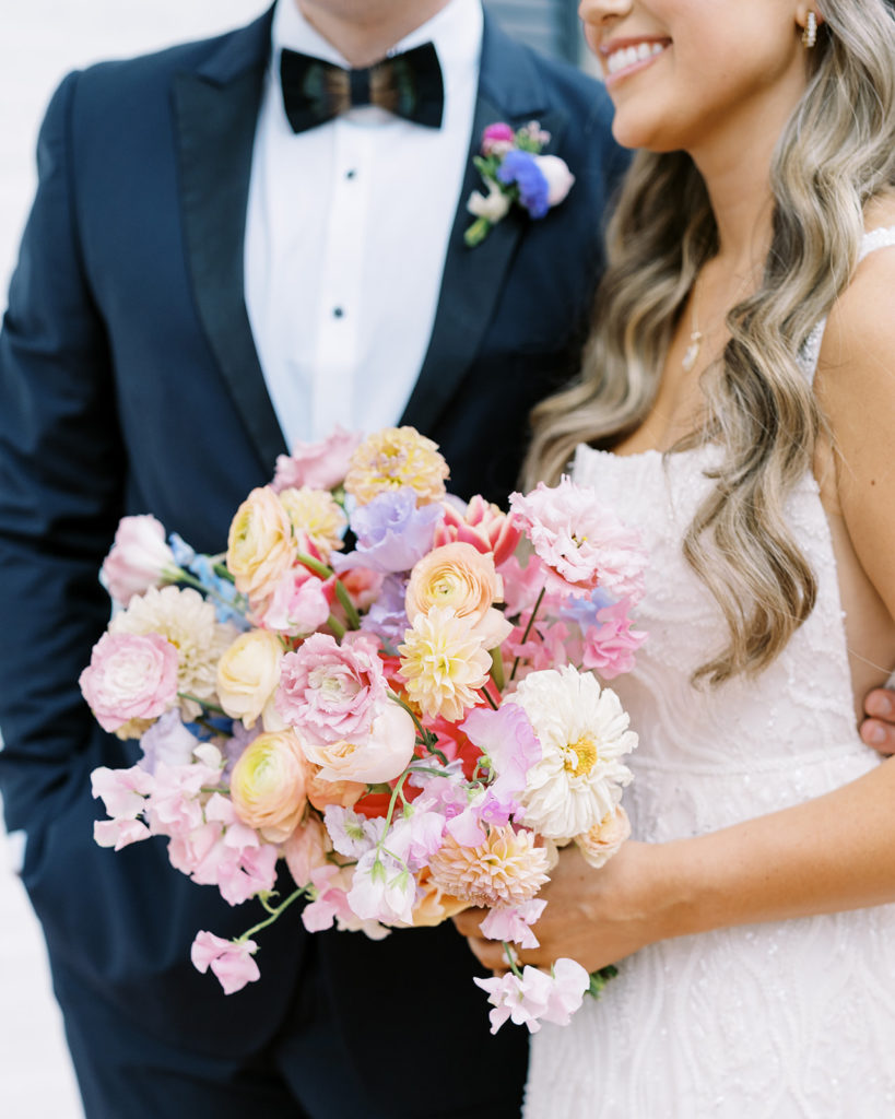 bride holding wedding bouquet while with groom