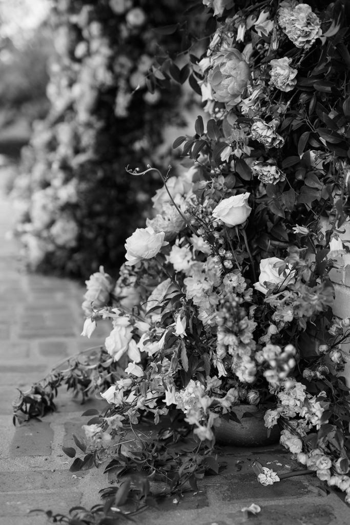 black and white wedding photos of flowers flowing up to wedding alter