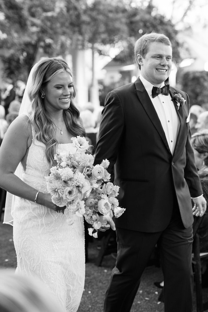 bride and groom walking down aisle after their wedding ceremony - black and white wedding photos