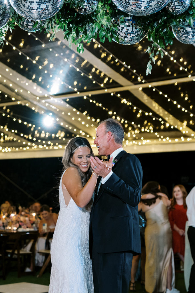 bride and father dancing during the night time under clear wedding tent with lights - wedding tents for rain