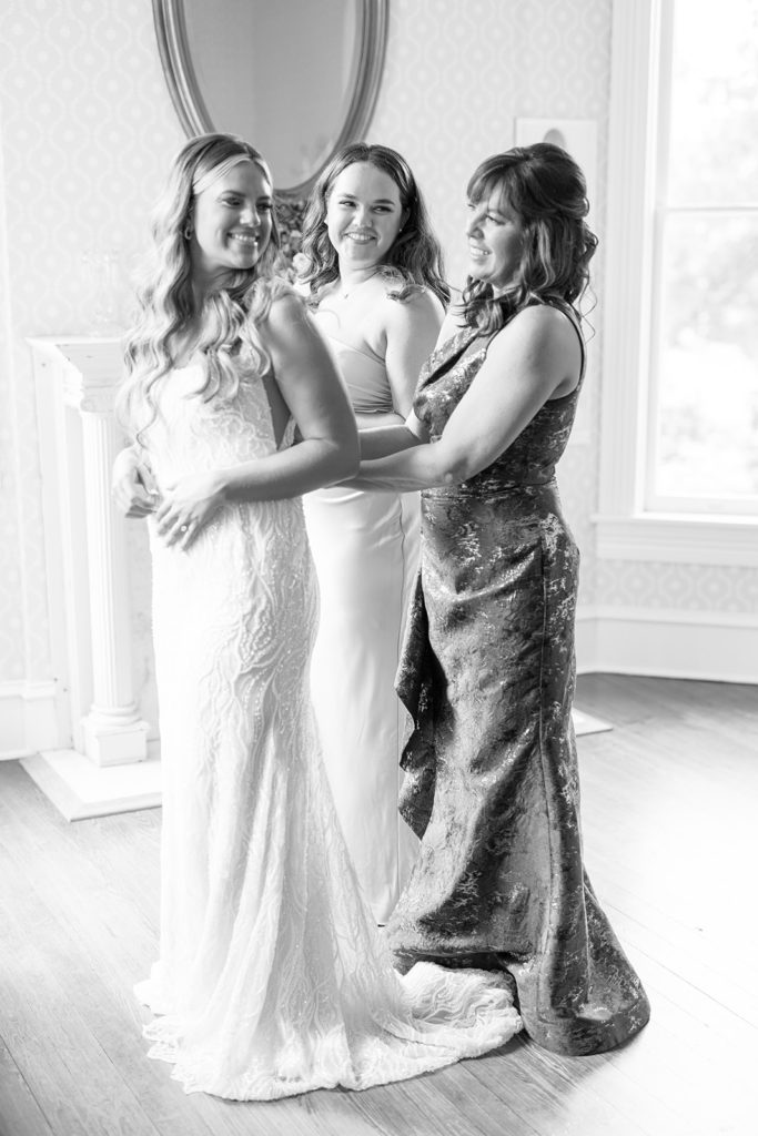 bride smiling at bridal party while getting ready for wedding