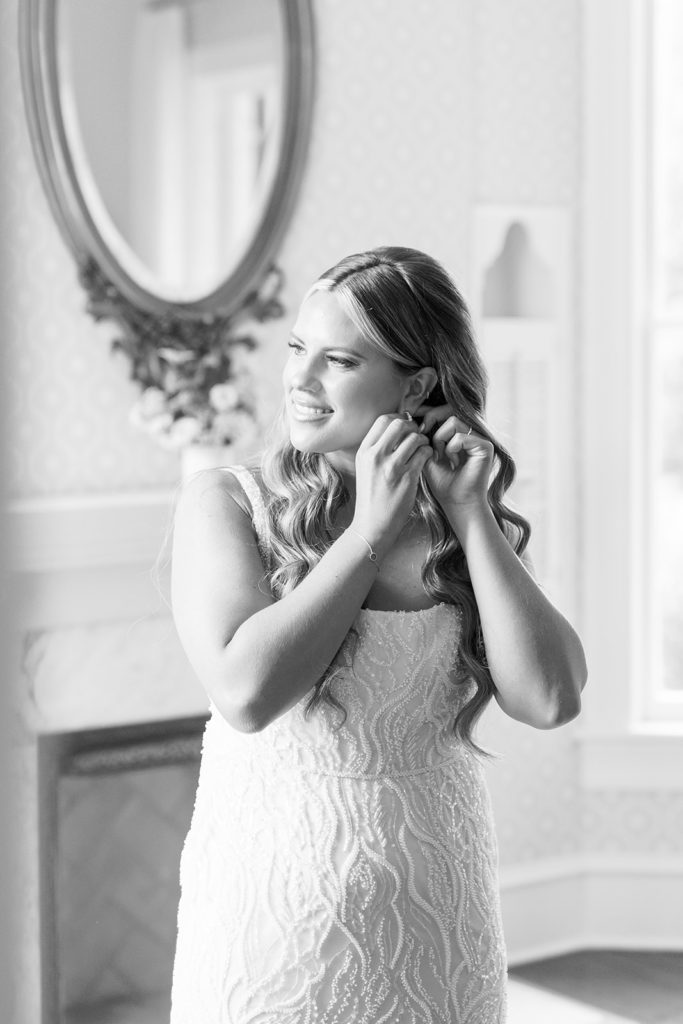 bride putting earrings on for wedding