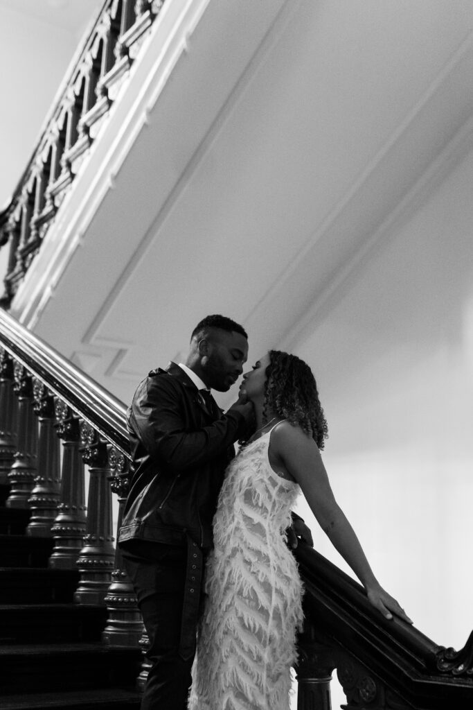 man holding womans face while standing on stairs 